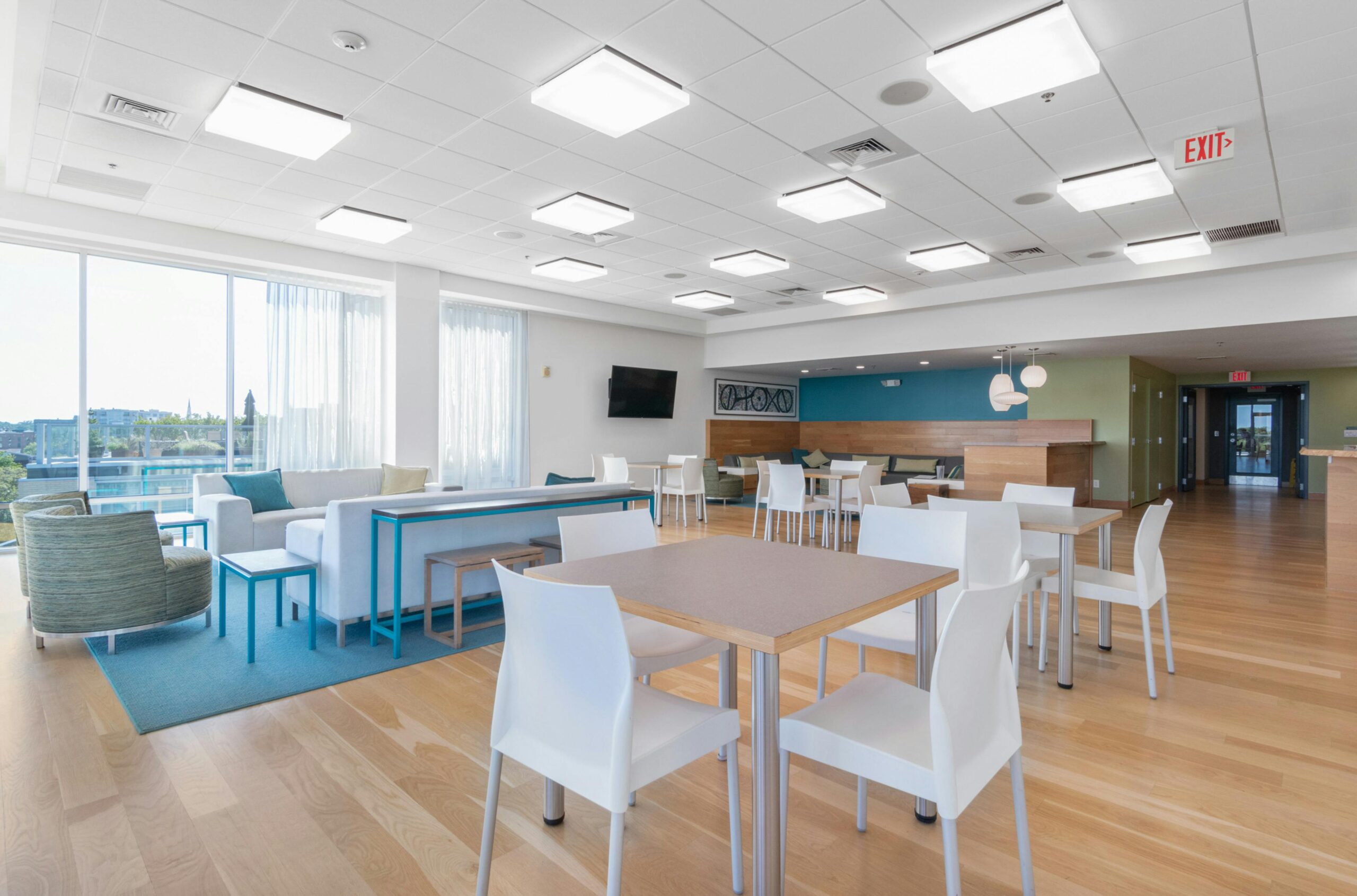 Students walking through a bright, modern school hallway with reception seating and plants